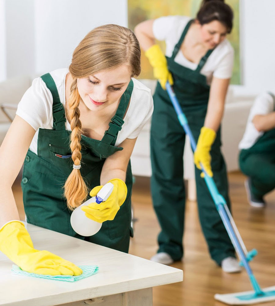 a group of people in overalls cleaning a room