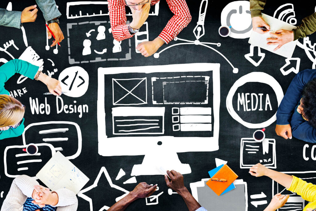 Computer, word bubbles, and the words “media” and “web design” drawn in marker with a group of people surrounding the images in a circle.