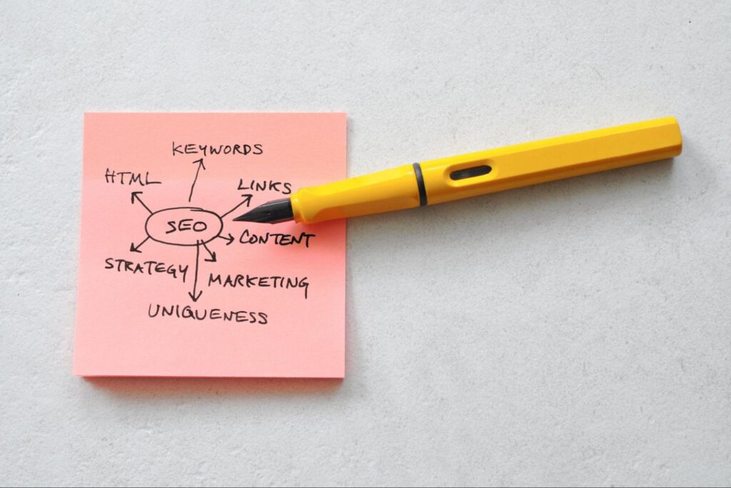 Word “SEO” in a drawn circle with arrows pointing toward words relating to content creation with a yellow pen.