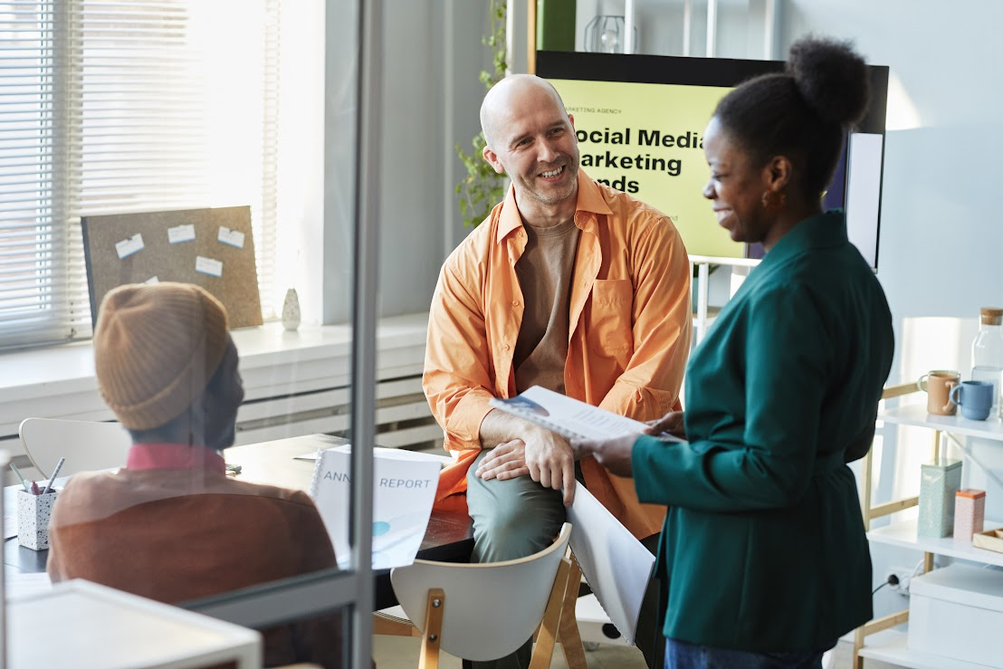 Three coworkers are having a conversation about social media marketing.